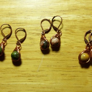 three pairs of stone earrings on wood